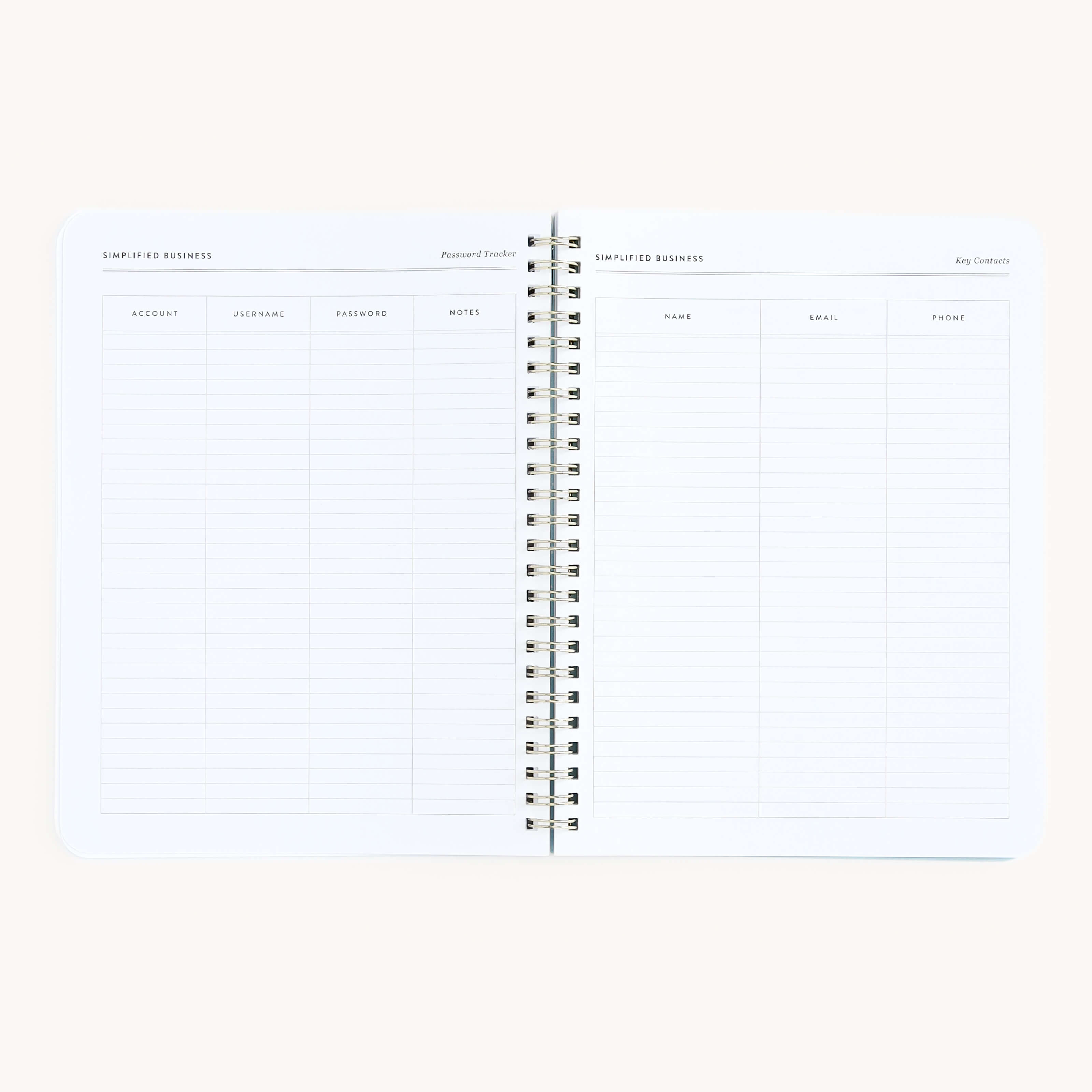 An open spiral-bound workbook from Simplifieds Workbook - Entrepreneurship series shows two sections. The left, ideal for planning, is titled Password Tracker with columns for account details. The right is for Key Contacts, listing name, email, and phone.