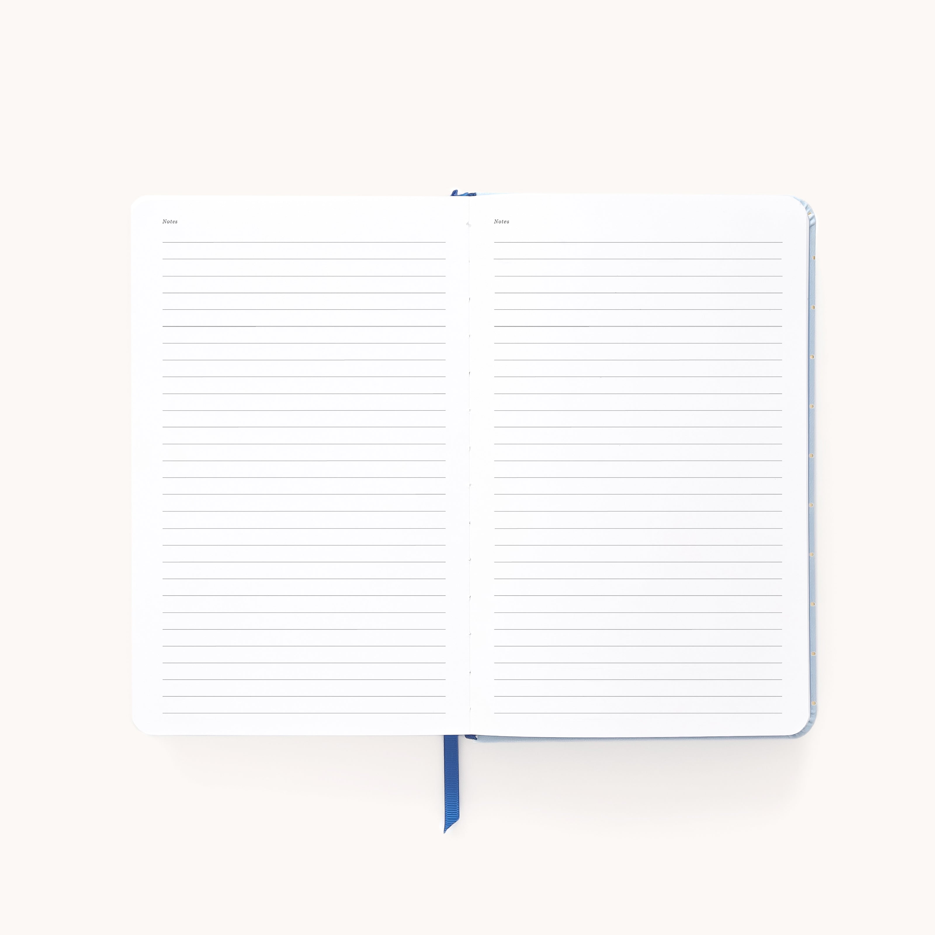The Simplified 2026 Bookbound Daily Dapperdesk Planner - Carolina Dot features lined pages with headings and a blue ribbon bookmark, lying flat and ready to help you organize your year.