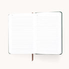 The 2025-2026 Simplified Dapperdesk Planner in Evergreen, with lined pages divided into Notes sections and a brown ribbon bookmark, invites detailed planning with its dark green bookbound cover.