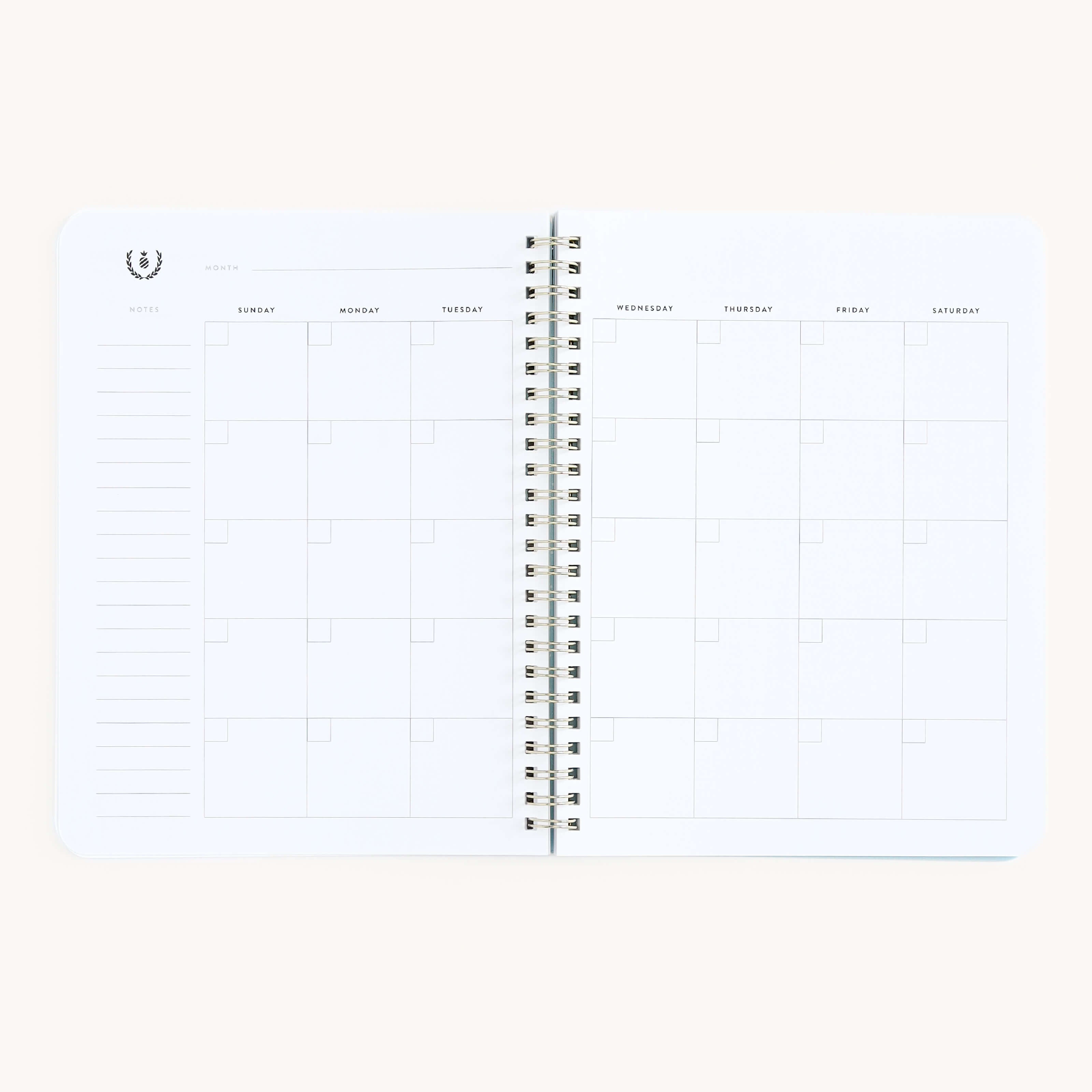 Simplifieds Workbook - Entrepreneurship is an open, spiral-bound monthly planner featuring blank squares for each day of the week, arranged in columns from Sunday to Saturday. A notes section is included on the left. The off-white background adds elegance to planning routines.