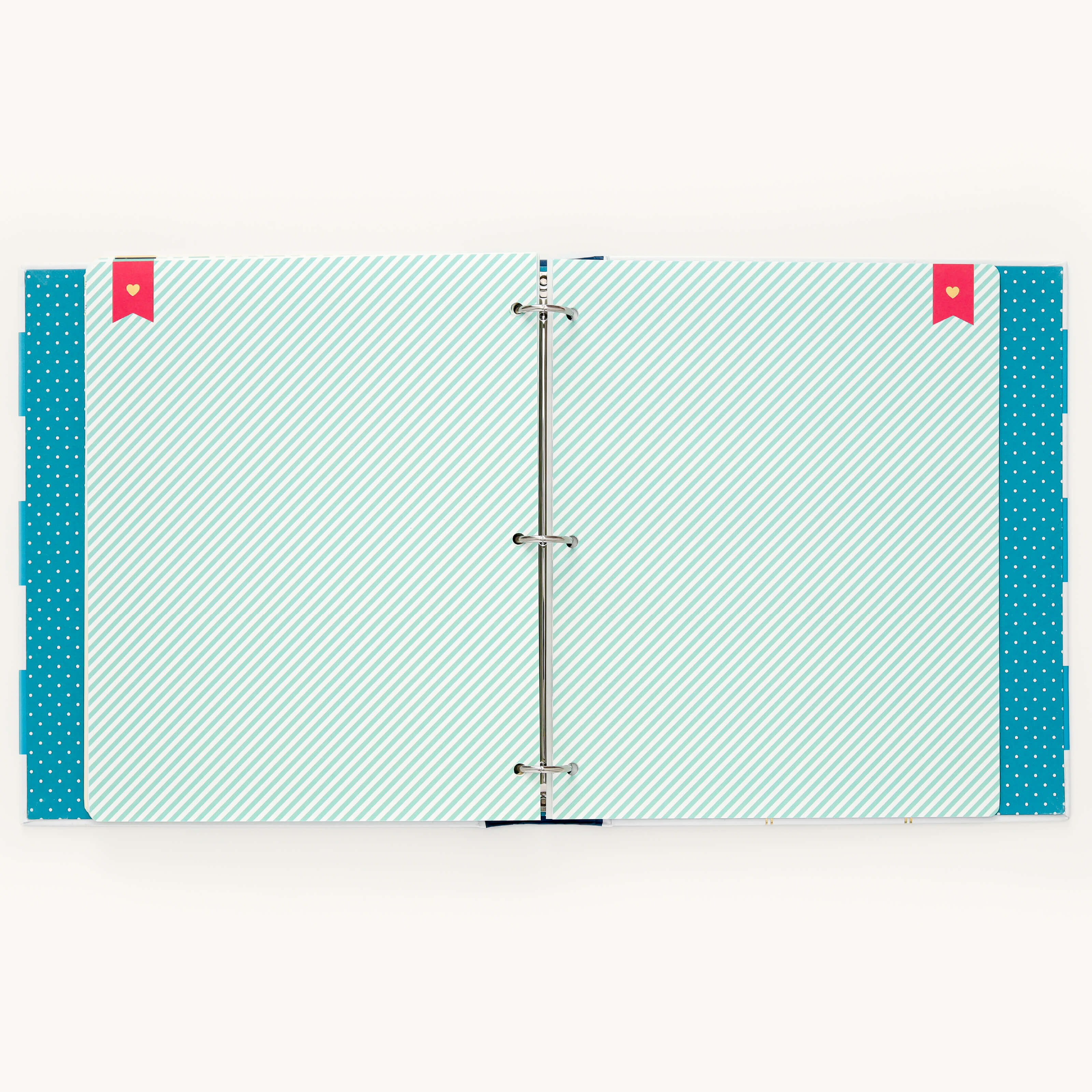 The Big Kid Book - Teal by Simplified is open, showing striped pages with polka dot edges and two red bookmarks in the top corners. Its metal rings at the center make it a perfect binder for tracking child growth milestones.