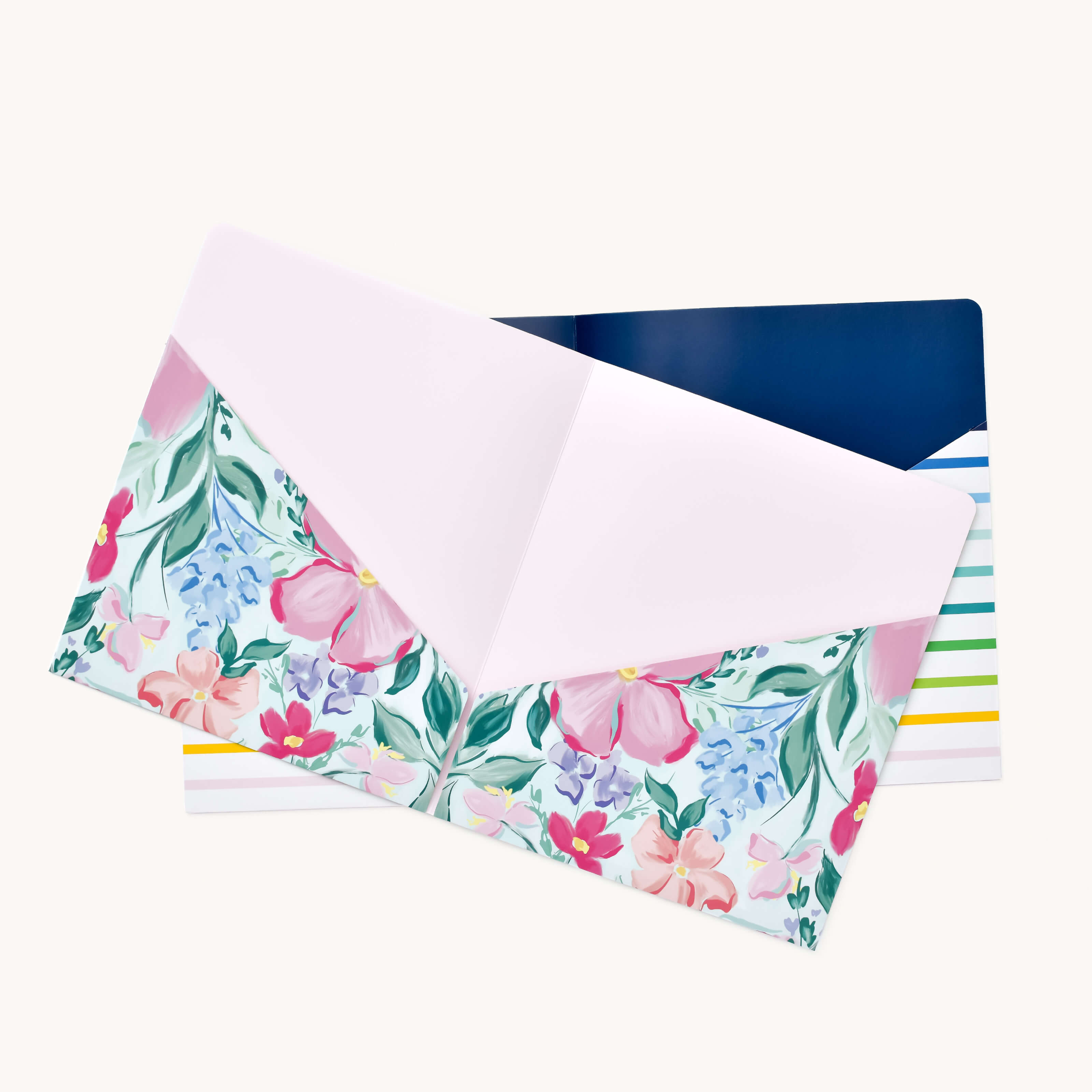 Two decorative folders from the Simplified® by Emily Ley Pocket Folder Set, Blush Magnolia & Happy Stripe—one floral with a pink interior, the other striped in navy, green, and yellow—are displayed on a light background.