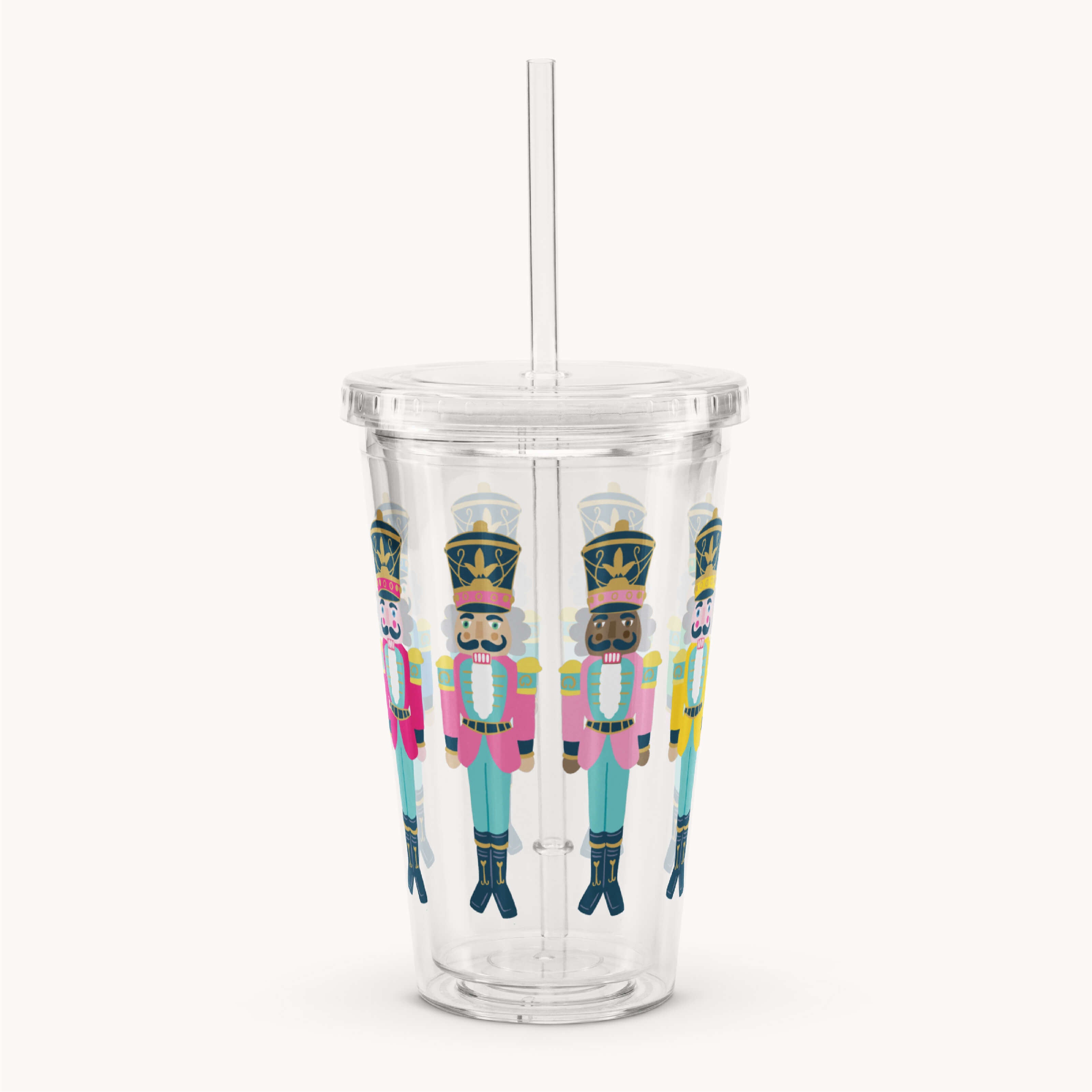 The Simplified Clear Tumbler - Nutcrackers is a 16oz cup with lid and straw, featuring colorful nutcracker illustrations—ideal as a reusable festive drinkware option.