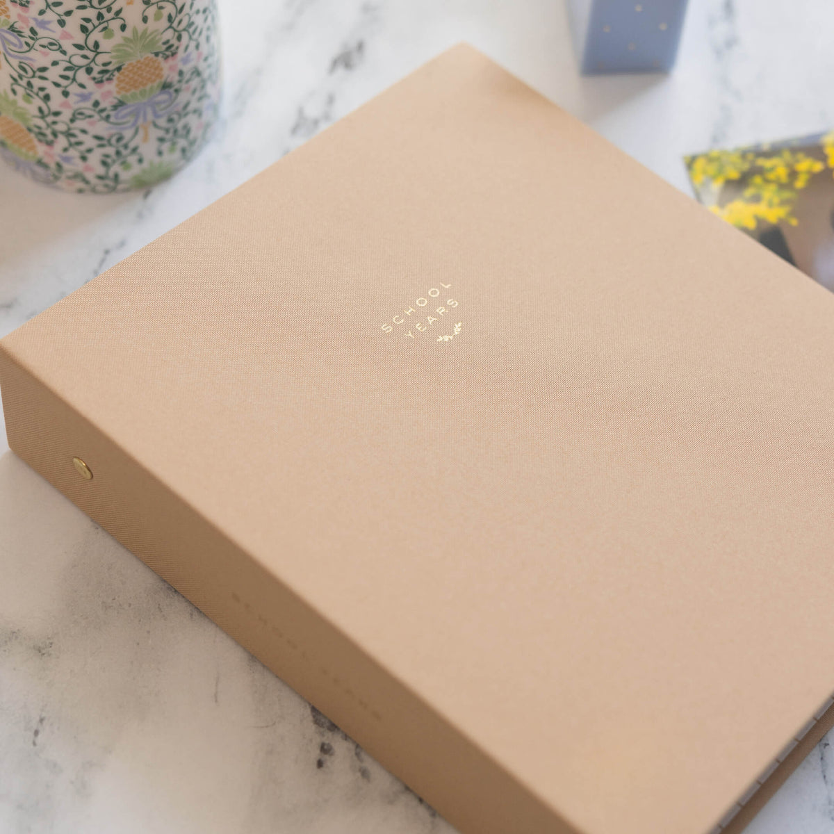 Fawn linen School Years Book on a marble counter.