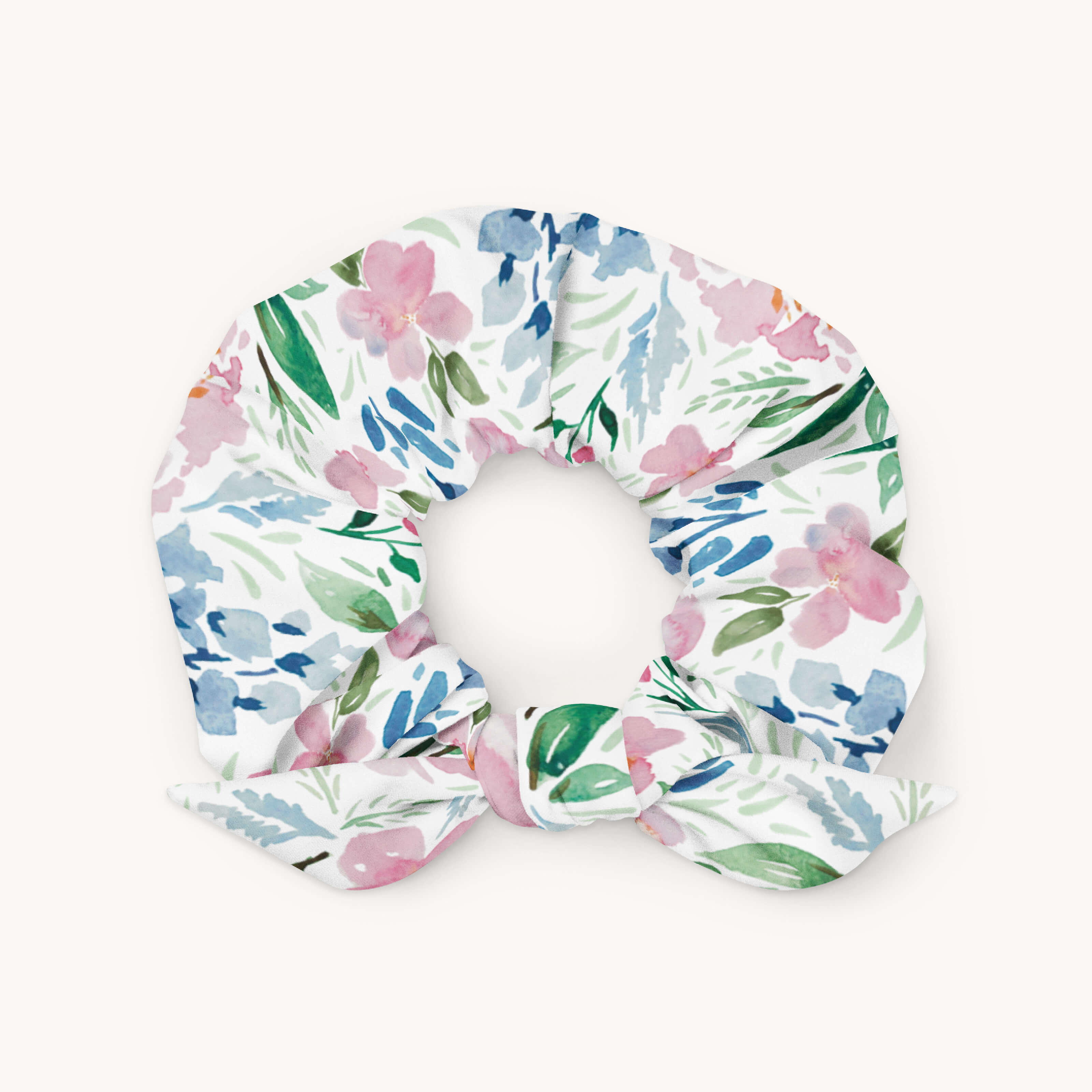The Simplified Scrunchie - Cottage Floral is a microfiber hair tie with a removable bow, featuring a colorful pink, blue, and green floral pattern on a white background.