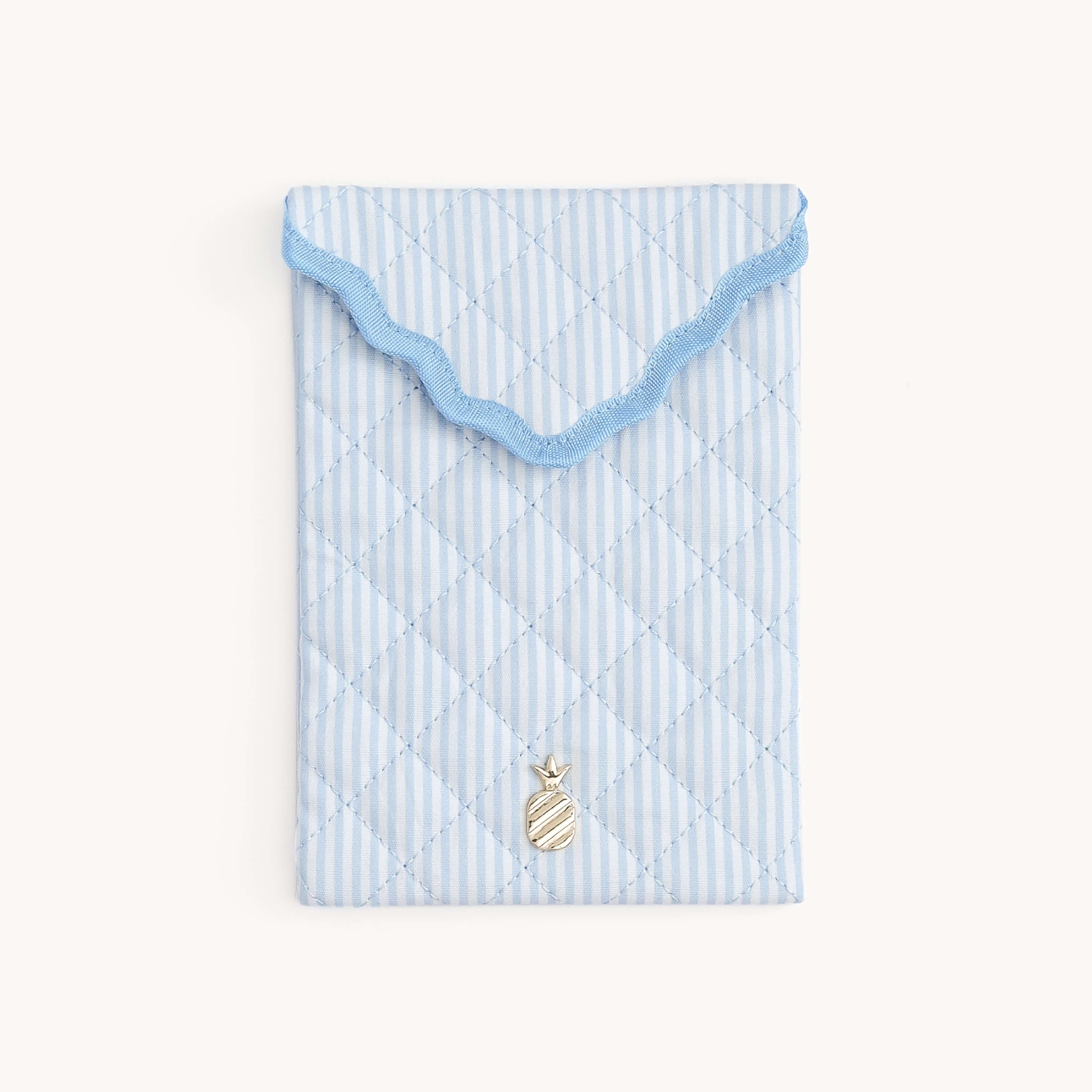 Light blue Blue Pinstripe Quilted E-Reader Case with a gold pineapple charm on a white background