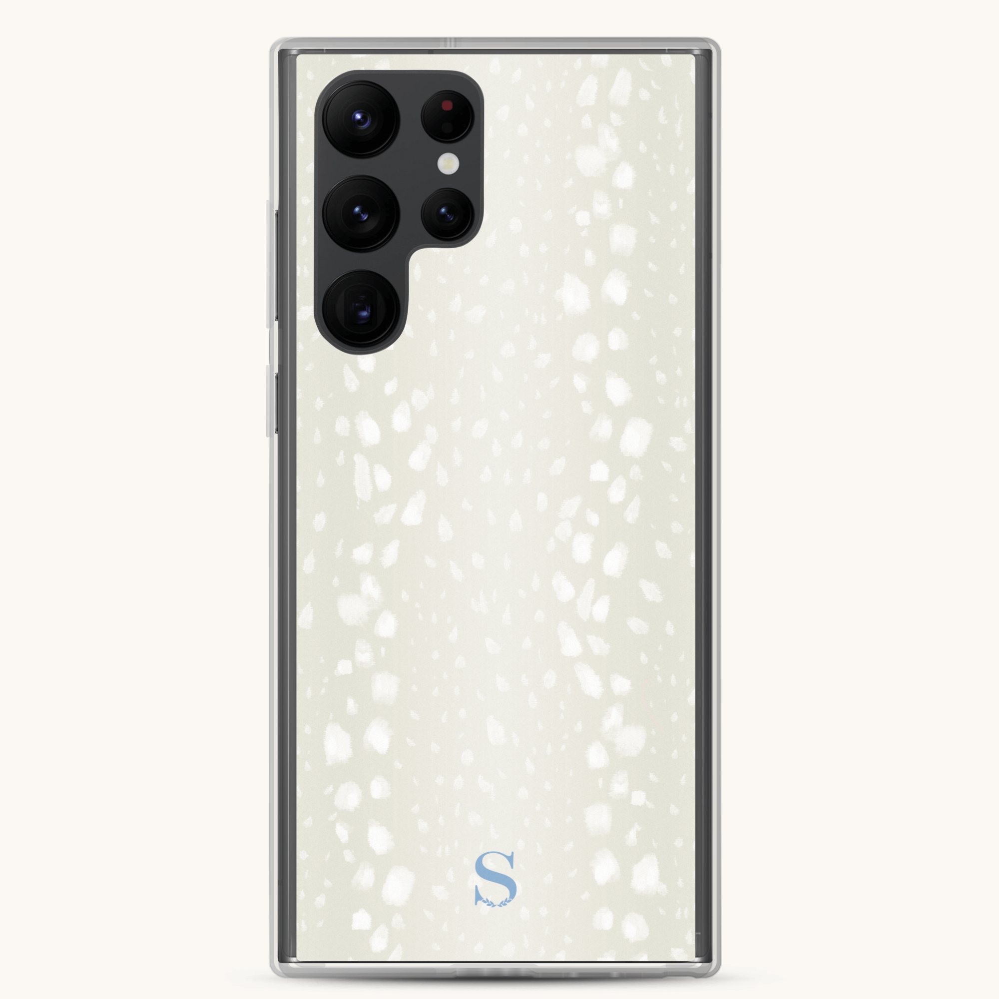 The Samsung Case - Ivory Antelope by Simplified features a light-colored, textured back with an elegant design of irregular white spots. Its multiple camera lenses align vertically in the top left corner, and a small S logo is elegantly placed at the bottom center.