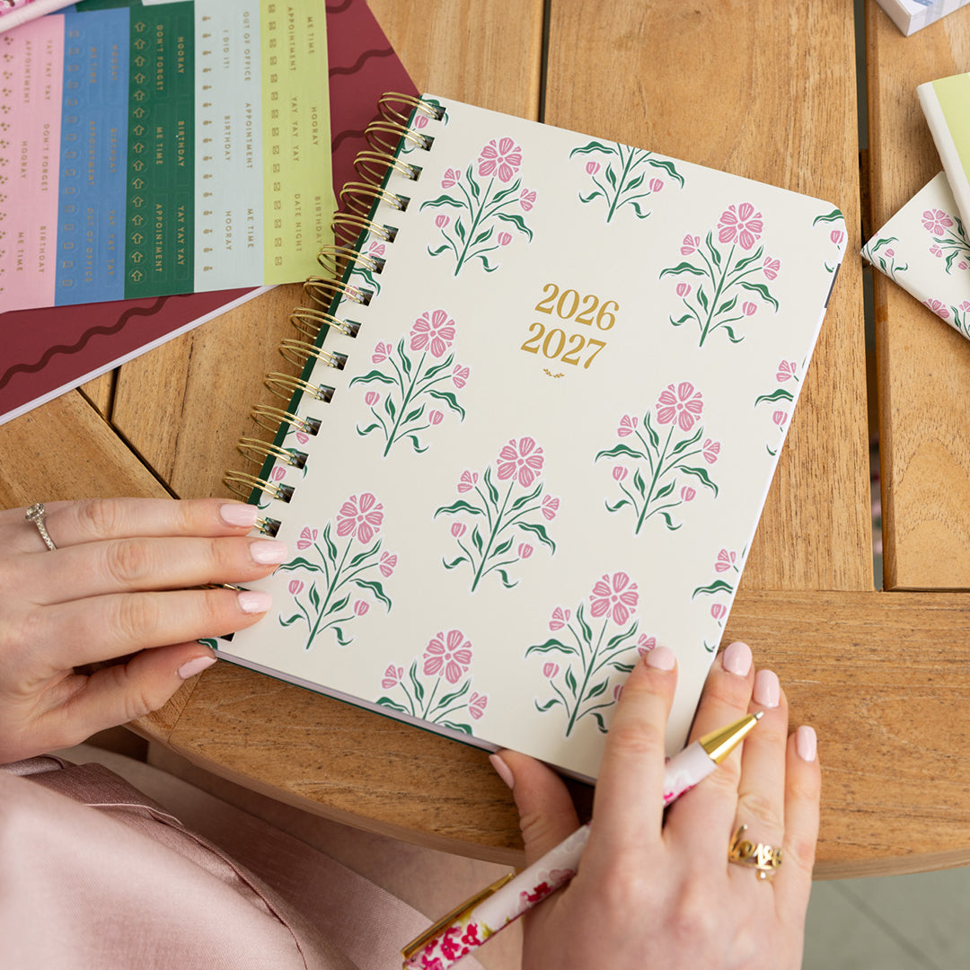 Small softcover weekly planner styled on desk with elegant details for portable, organized weekly planning