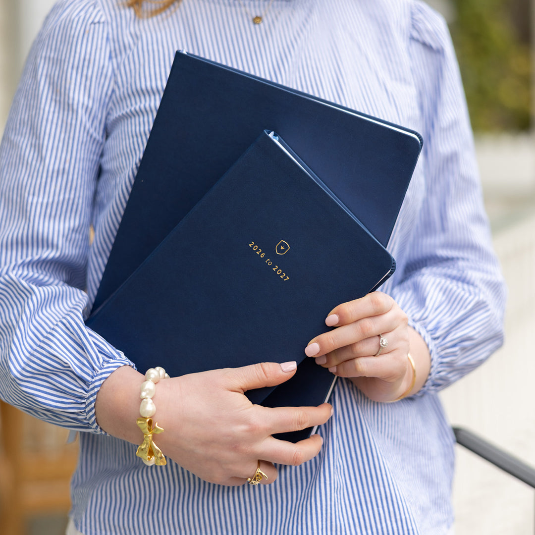 Woman holding Daily and Weekly Navy Dapperdesk Planners