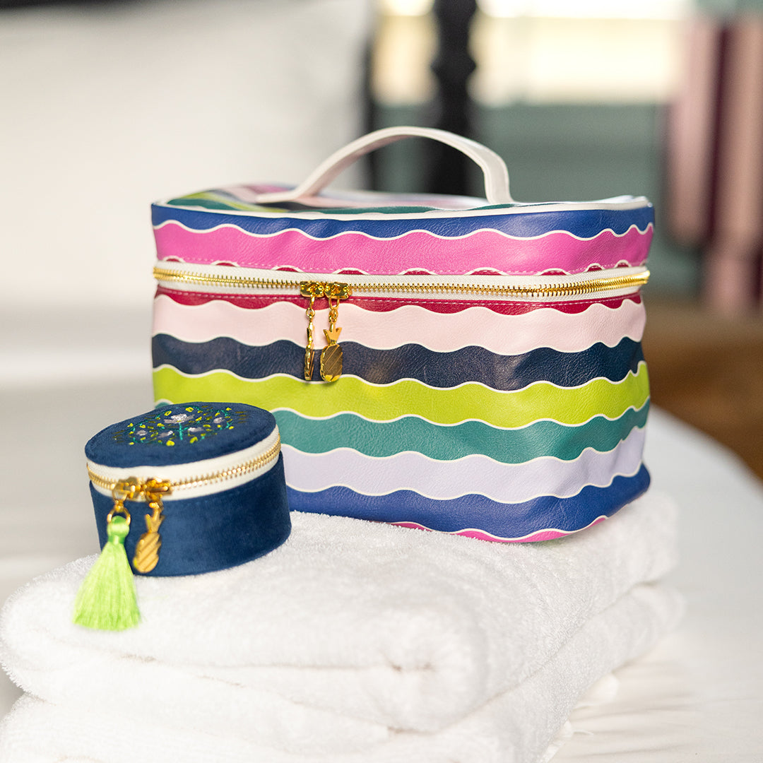 Pastel rainbow wavy stripe makeup bag styled on bathroom counter – spacious travel cosmetic case with structured shape