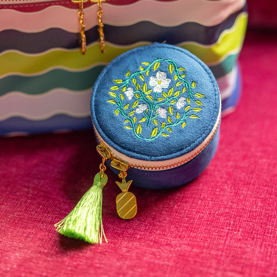 Navy floral round jewelry travel case with tassel zipper pull by Simplified by Emily Ley next to Train Case set