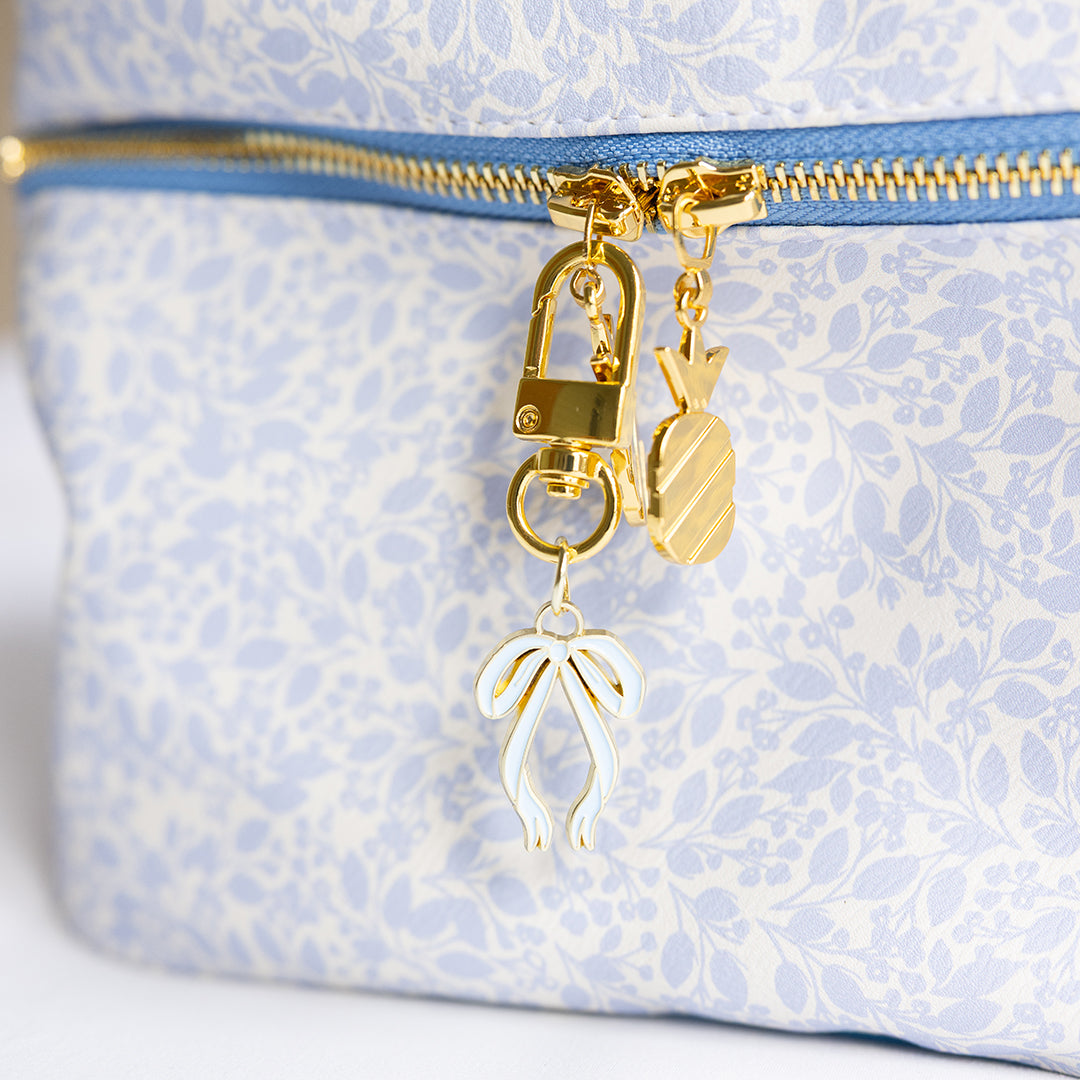 Bow enamel charm clipped to Misty Meadow Train Case Set zipper by Simplified by Emily Ley
