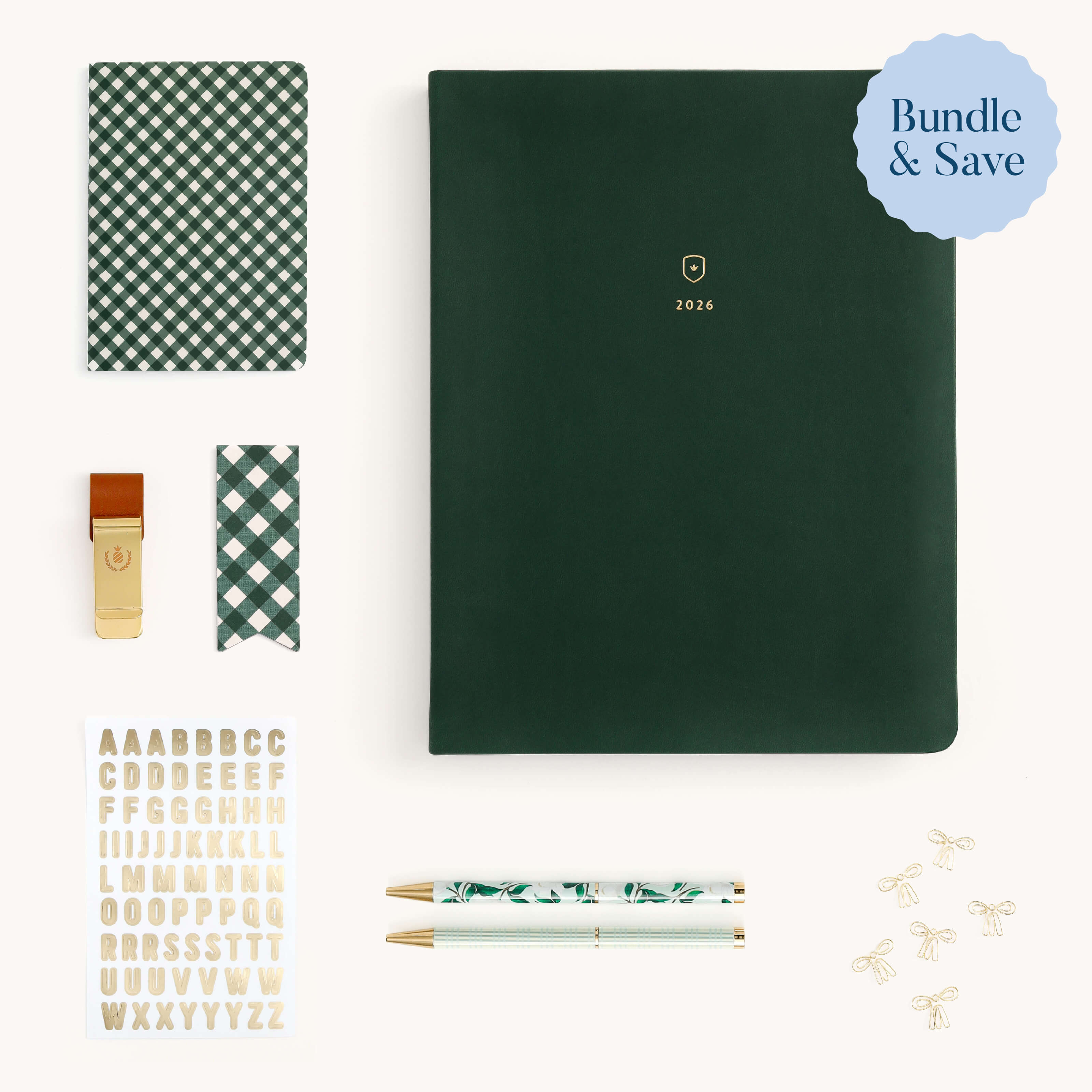 The Simplified® by Emily Ley Weekly Dapperdesk Ultimate Bundle features a dark green 2024 planner, checkered notebook, gold whistle, checkered ribbon, gold letter stickers, two patterned pens, and small gold paper clips. Bundle & Save badge shown.