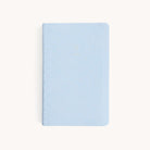 A closed Simplified 2026 Bookbound Daily Dapperdesk Planner in Carolina Dot, featuring a light blue leatherette cover with small gold dots, is displayed on a plain white background.