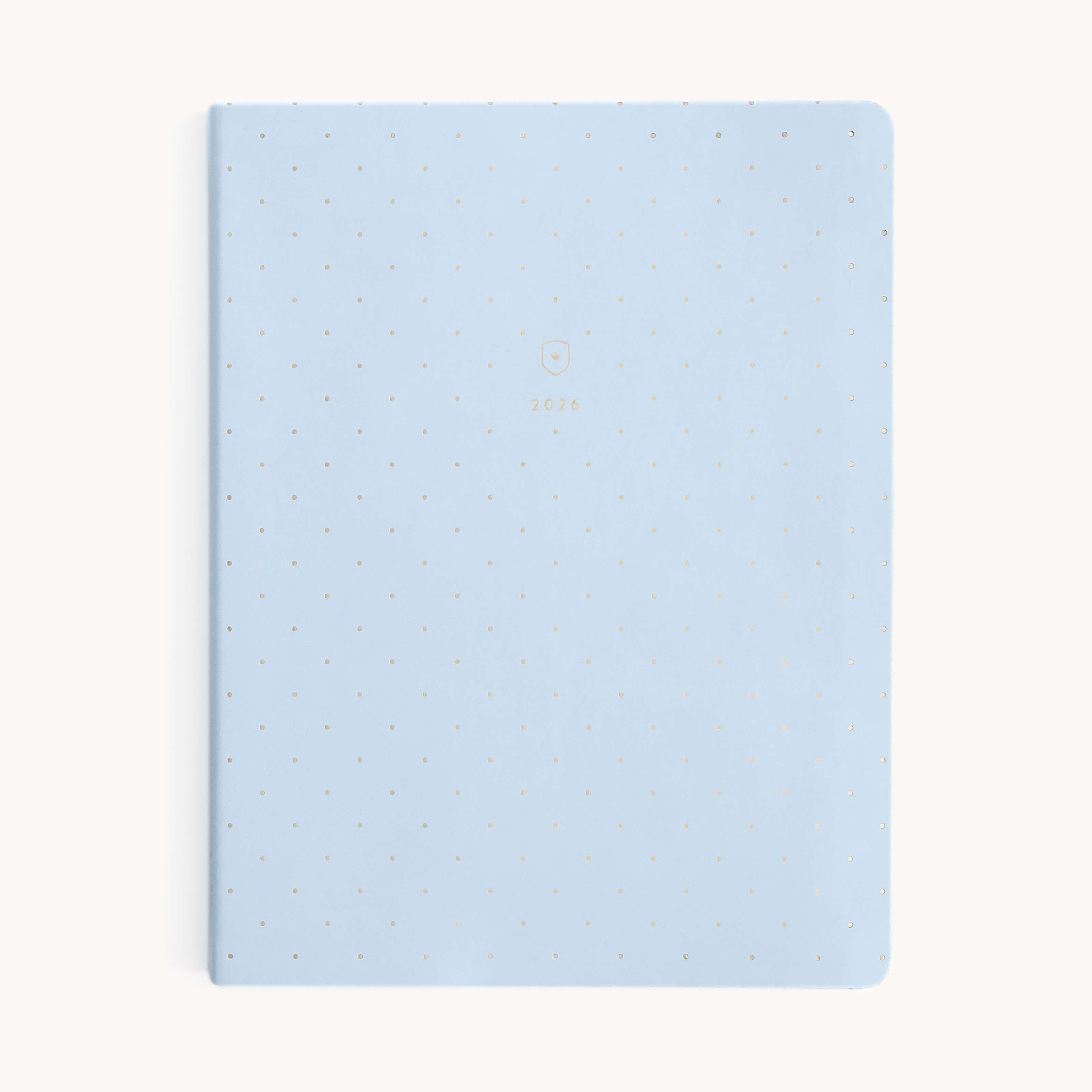The Simplified Replacement 2026 Bookbound Weekly Dapperdesk Planner - Carolina Dot features a light blue cover with gold polka dots and 2026 in gold at the center, displayed on a plain white background.