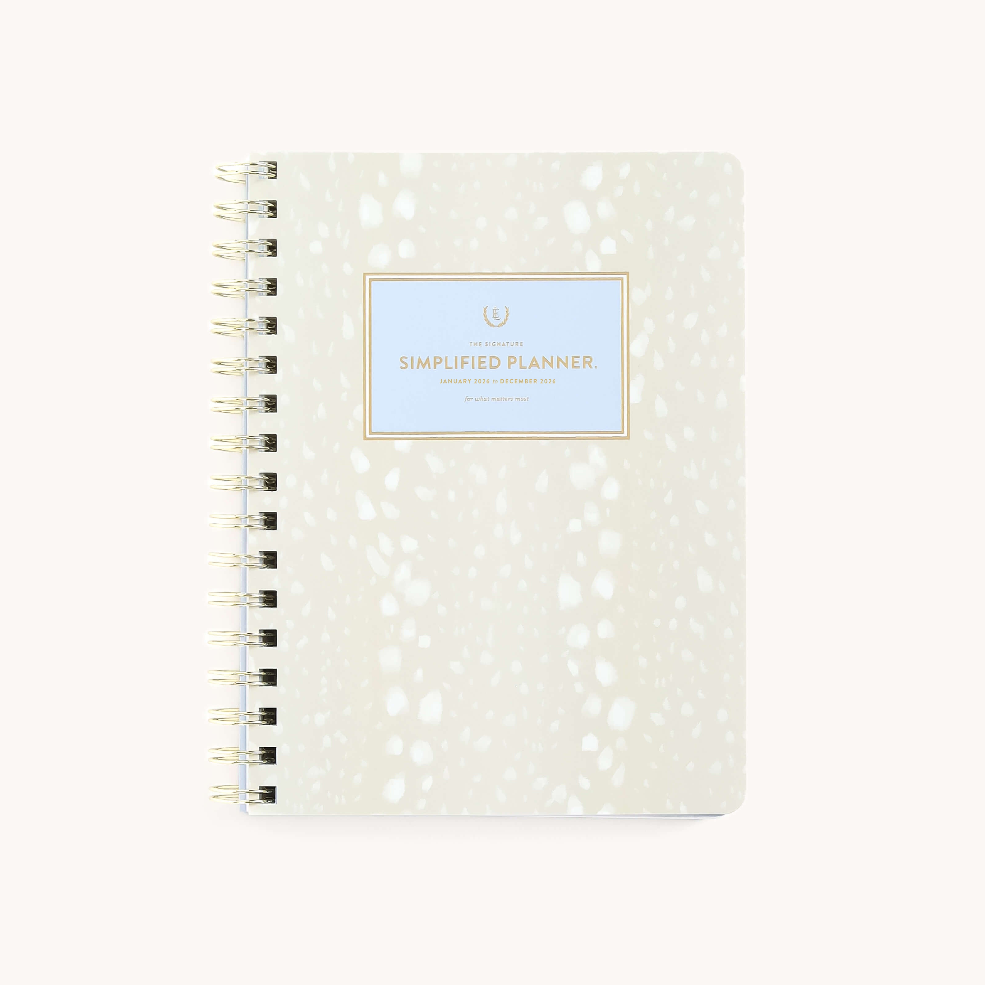The 2026 Softcover Weekly Simplified Planner - Ivory Antelope by Simplified features a cream and white speckled cover with Simplified Planner in gold and blue on the front, ideal for streamlined planning and simplified prep work.