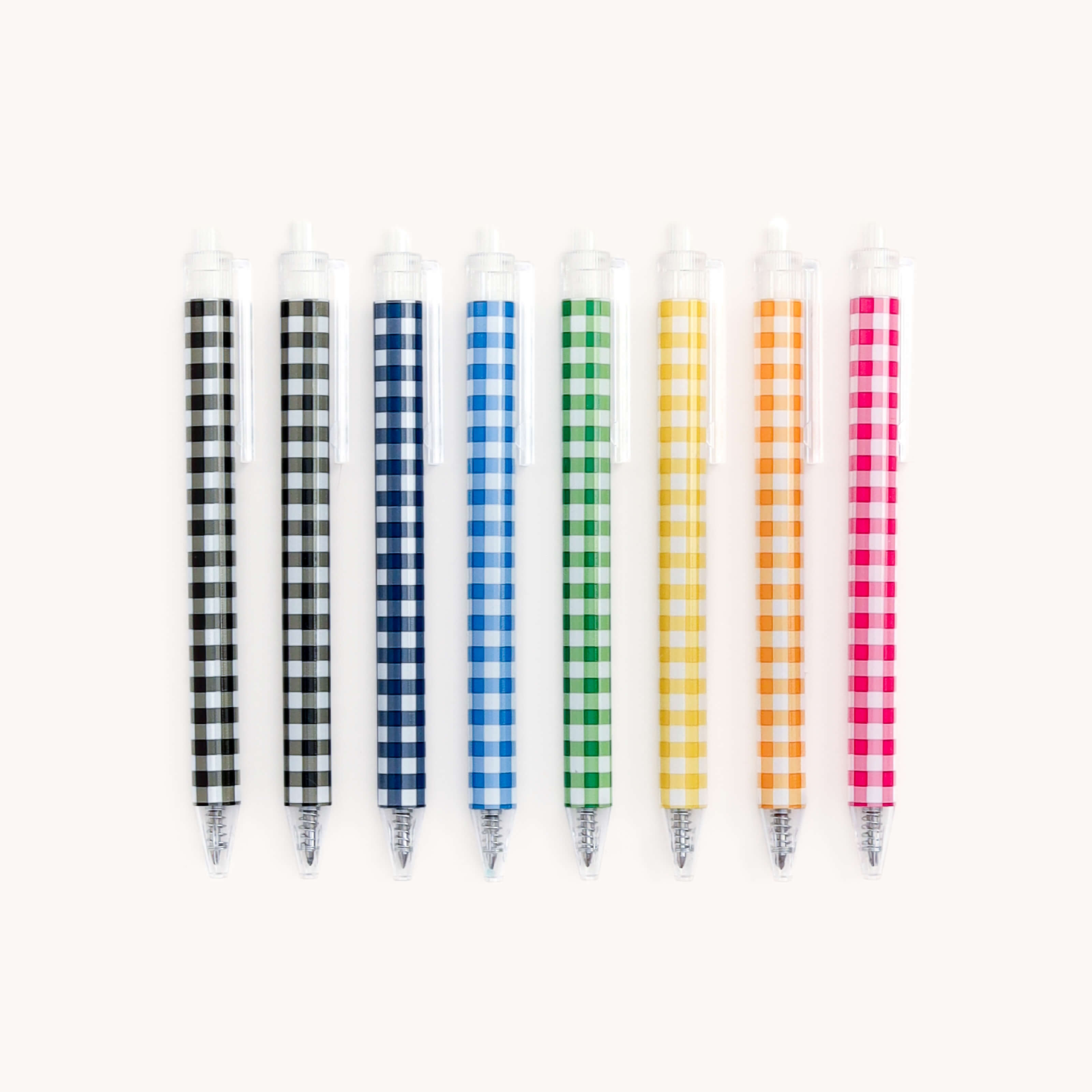 The Simplified Gel Pen Set - Gingham includes eight pens in black, blue, green, yellow, orange, and pink checkered patterns. Each pen features a retractable tip and transparent clip and is aligned vertically against a light background.