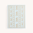 The Simplified Linen Journal - Block Floral features a light blue linen hardcover with an ornate, hand-drawn gold floral and geometric design on the front, displayed against a plain white background.