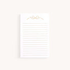 The Simplified Lined Notepad - Gold Bow features horizontal lines and a chic gold bow design on a light background, making it a charming gift for any occasion.