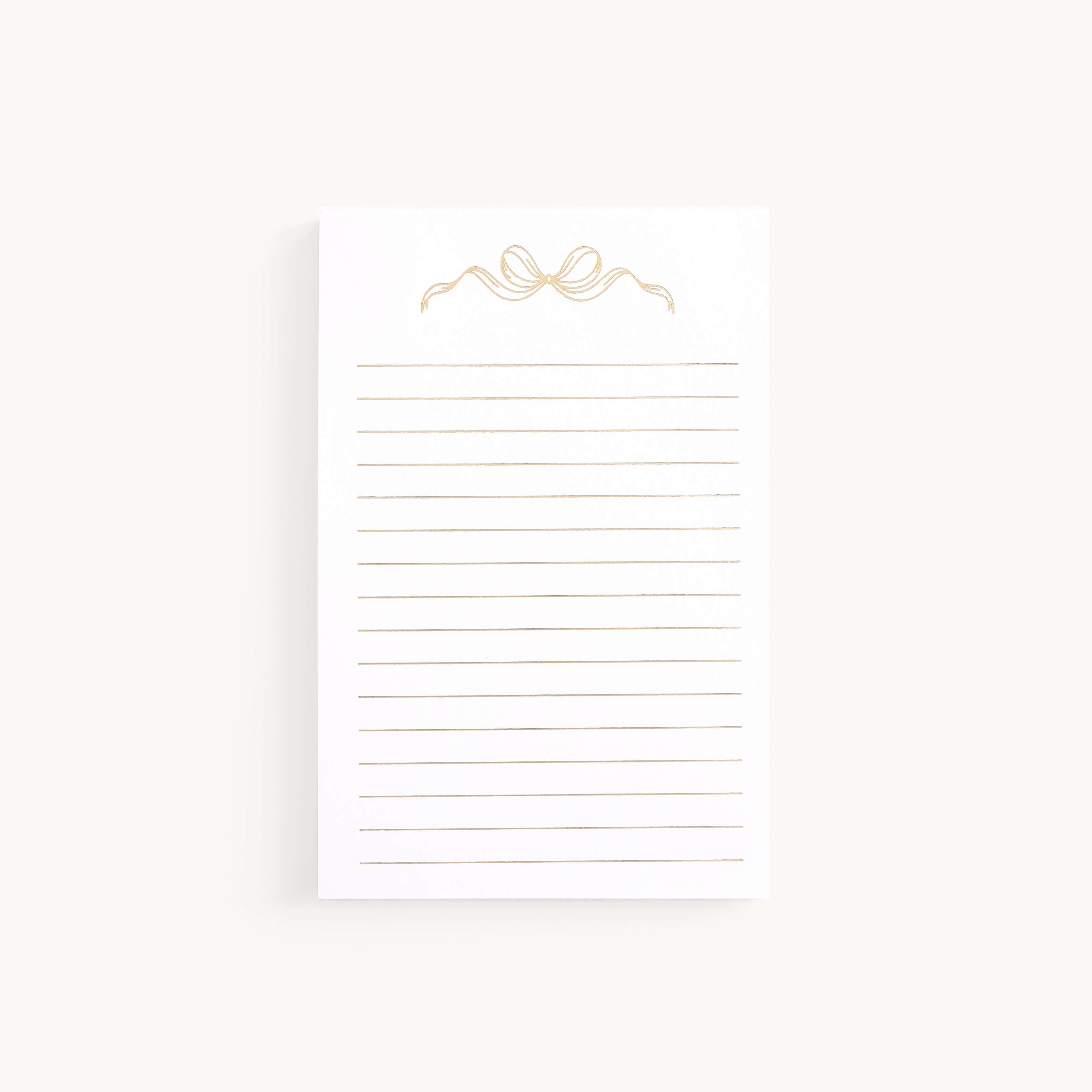 The Simplified Lined Notepad - Gold Bow features horizontal lines and a chic gold bow design on a light background, making it a charming gift for any occasion.