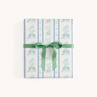 A beautifully wrapped gift box features Simplifieds Gift Wrap Roll - Block Floral, showcasing light blue and green floral patterns and tied with a green ribbon—perfect for holiday gifts.