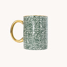 Emerald Floral Ceramic Mug, reverse side, with the gold handle on the left and an all-over green leaf and berry print