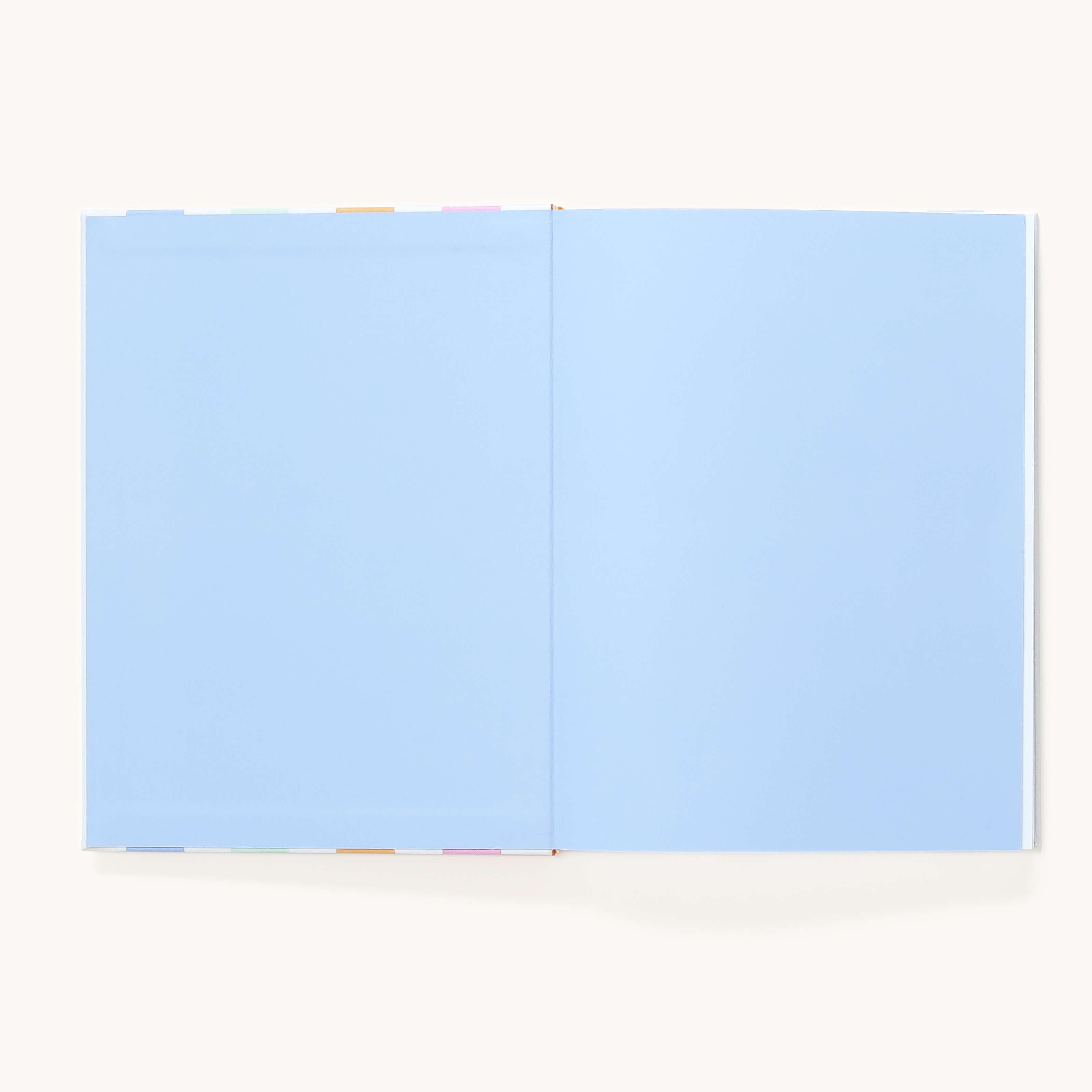 The Simplified Linen Journal - Back and Forth features light blue blank pages with multicolored divider tabs, shown open against a plain background—perfect for deepening connection as a back-and-forth journal.