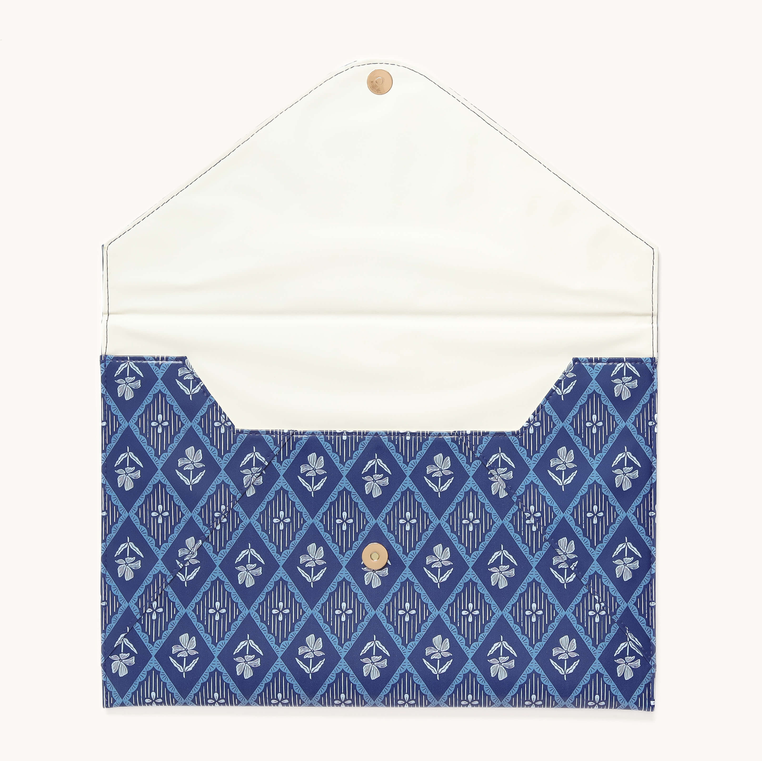The Simplified Leatherette Tech Case - Block Floral features a blue envelope-style design with a diamond and floral pattern, a button snap closure at the top, and opens to reveal a cream-colored interior.