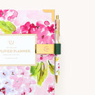 Brass pen clip attached to planner with Evergreen design for keeping pens accessible and neatly stored on the go