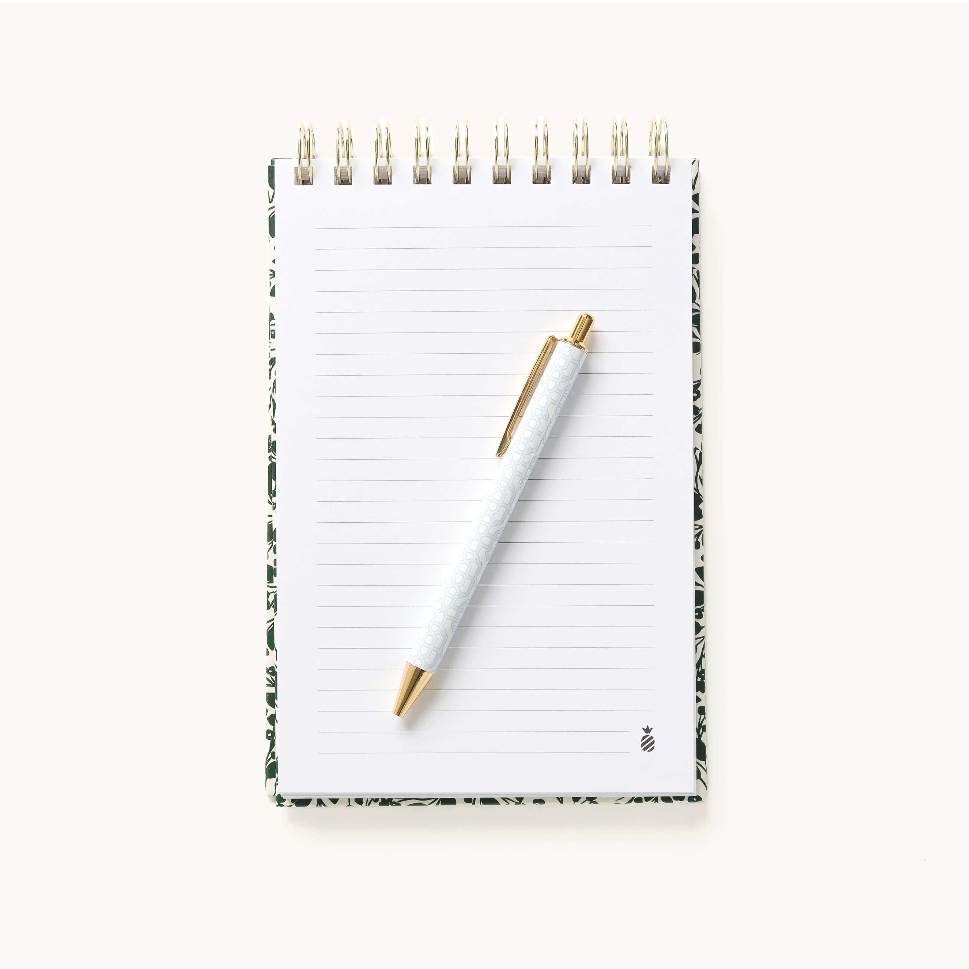 Open blank lined page in the Emerald Floral Top Spiral Notebook with a gold pen