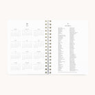 An open 2026 Softcover Weekly Simplified Planner - Happy Stripe by Simplified shows a 2026 yearly calendar on the left and a list of 2026 holidays on the right, all in black text on white paper for easy planning.