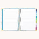 An open 2026 Spiral Weekly Simplified Planner – Faraway Land by Simplified lays flat on a light background, showing lined Notes pages and colorful tab dividers, perfect for organizing your weekly tasks.
