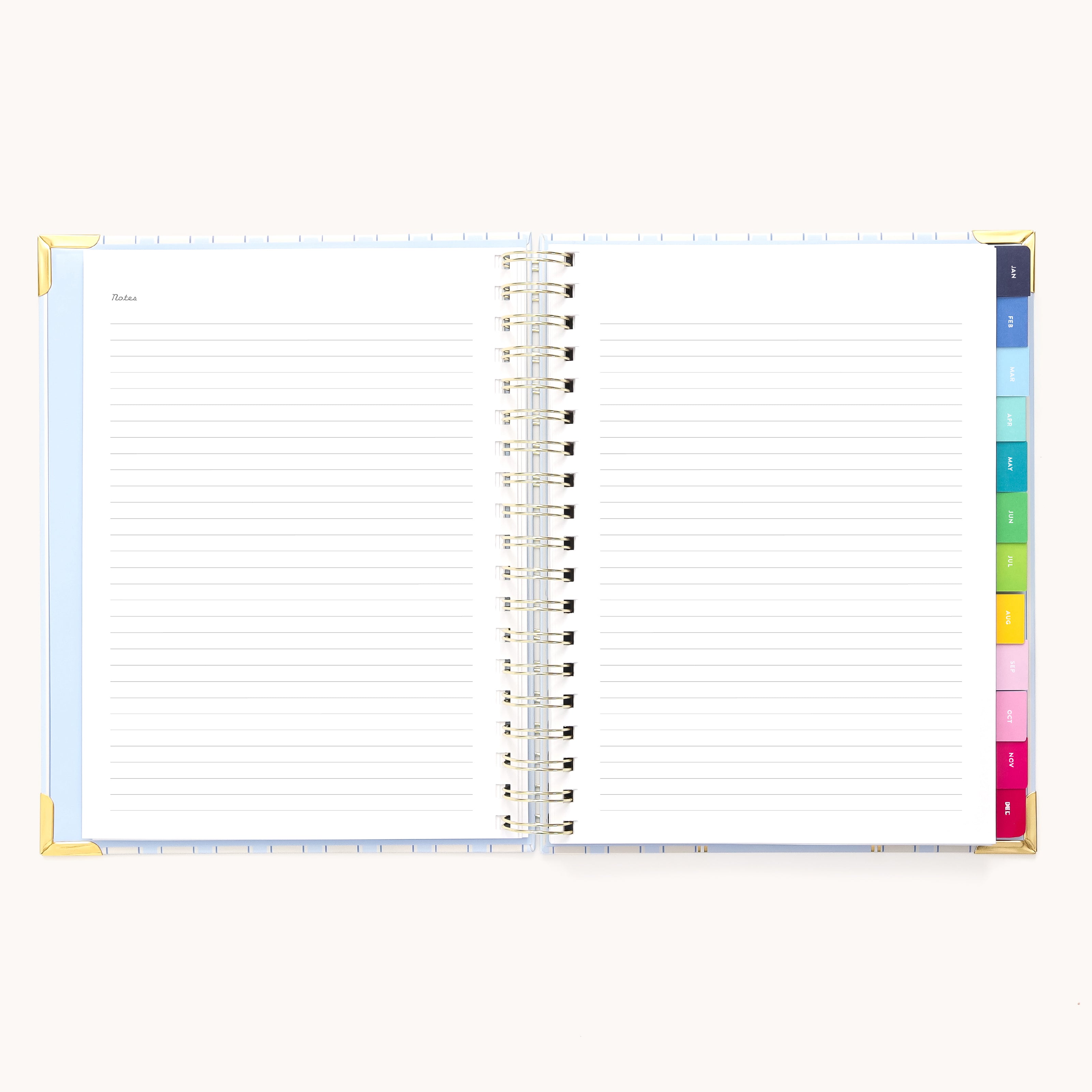 An open 2026 Spiral Weekly Simplified Planner - Serene Stripe by Simplified features lined pages, gold corner protectors, and colorful tab dividers on the right, displayed against a light background.