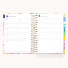 The 2026 Spiral Daily Simplified Planner - Cottage Floral by Simplified is shown open, revealing two daily pages with 6 AM–7 PM time slots, to-do and notes sections, and colorful tab dividers—a perfect planner for organized days.