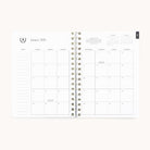 The Simplified 2026 Softcover Weekly Planner - Happy Stripe features a spiral binding, a two-page monthly spread for January 2026, lined notes on the left, and mini calendars for December 2025 and February 2026—ideal for simplified planning.