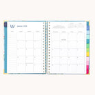 The 2026 Spiral Weekly Simplified Planner - Faraway Land by Simplified features a January 2026 monthly calendar on the left and a weekly planner with notes on the right, plus colorful tabs for easy organization—combining function and style.