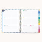 An open 2026 Spiral Weekly Simplified Planner – Camp Gingham by Simplified, featuring lined daily sections, colorful tab dividers, a patterned cover with gold corners, and weekly pages dated January 1–7.