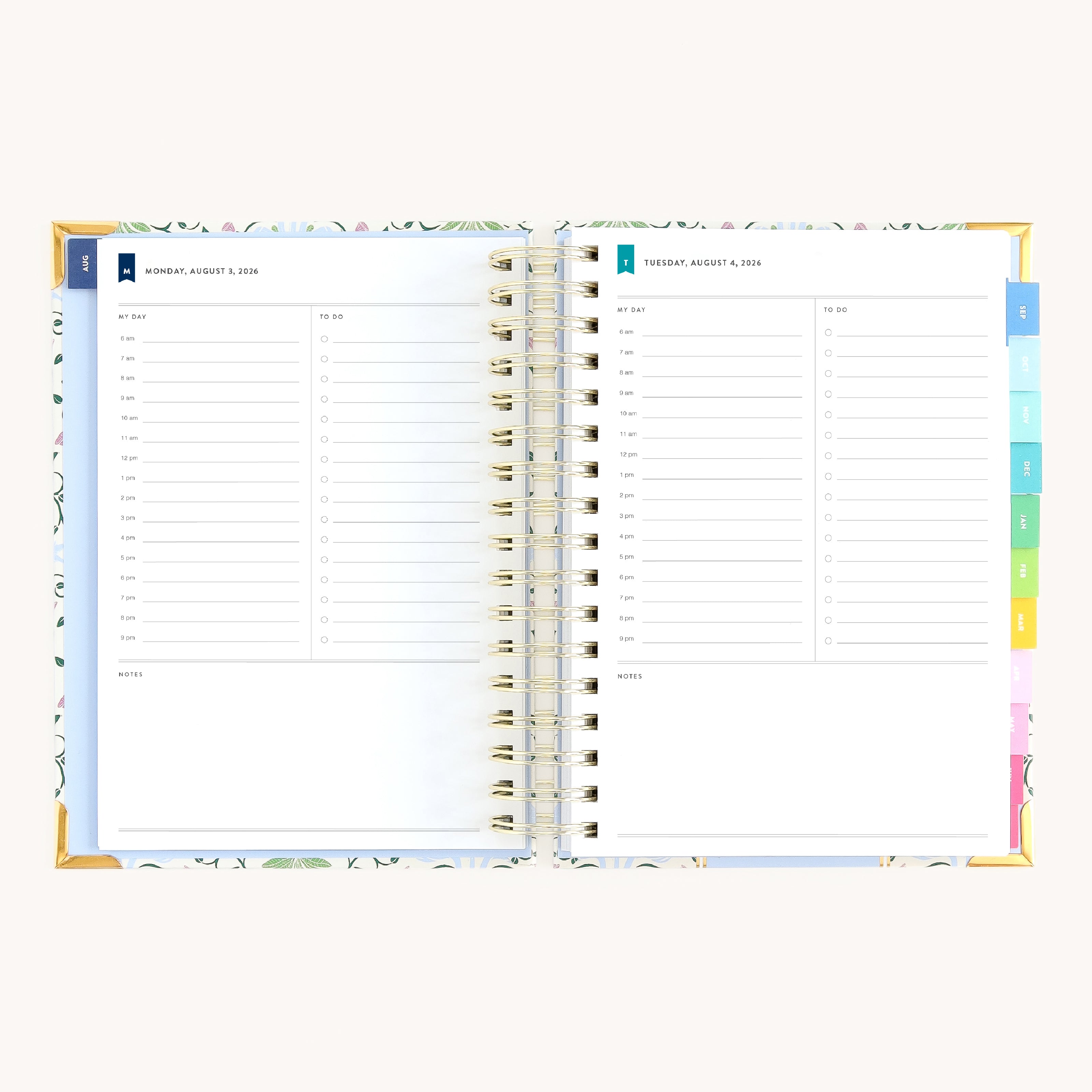 Spiral daily planner open to Monday and Tuesday pages with hourly schedule, to-do lists, and space for notes