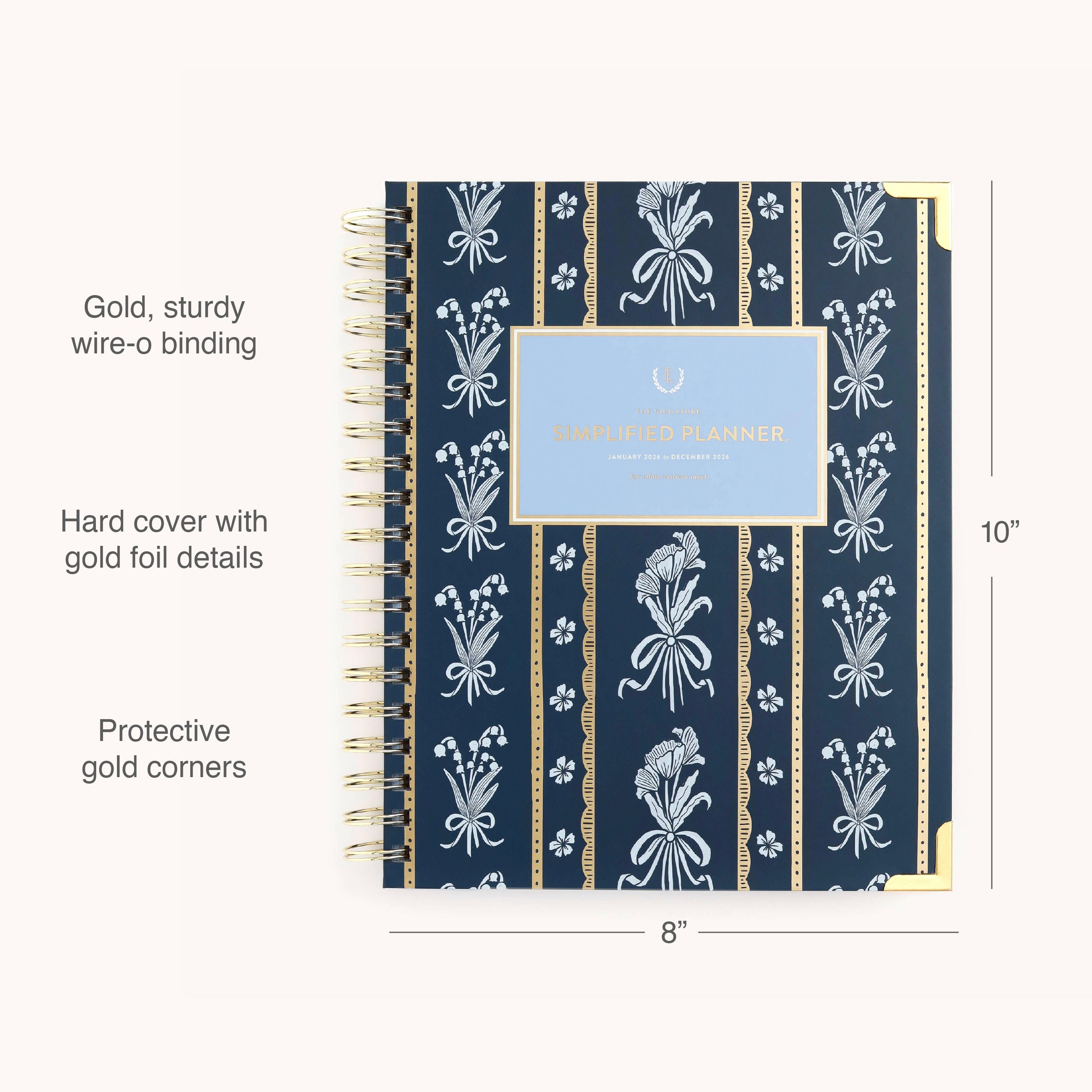 The 2026 Spiral Weekly Simplified Planner - Poppy Posies by Simplified features a navy blue hardcover with white floral design, gold foil accents, sturdy gold wire-o binding, protective gold corners, and measures 10” x 8”.