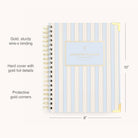 The 2026 Spiral Weekly Simplified Planner - Serene Stripe by Simplified features blue and white stripes, gold wire-o binding, gold foil accents, protected corners, “Simplified Planner” on the cover, and measures 10” x 8”. This is a 12-month planner.