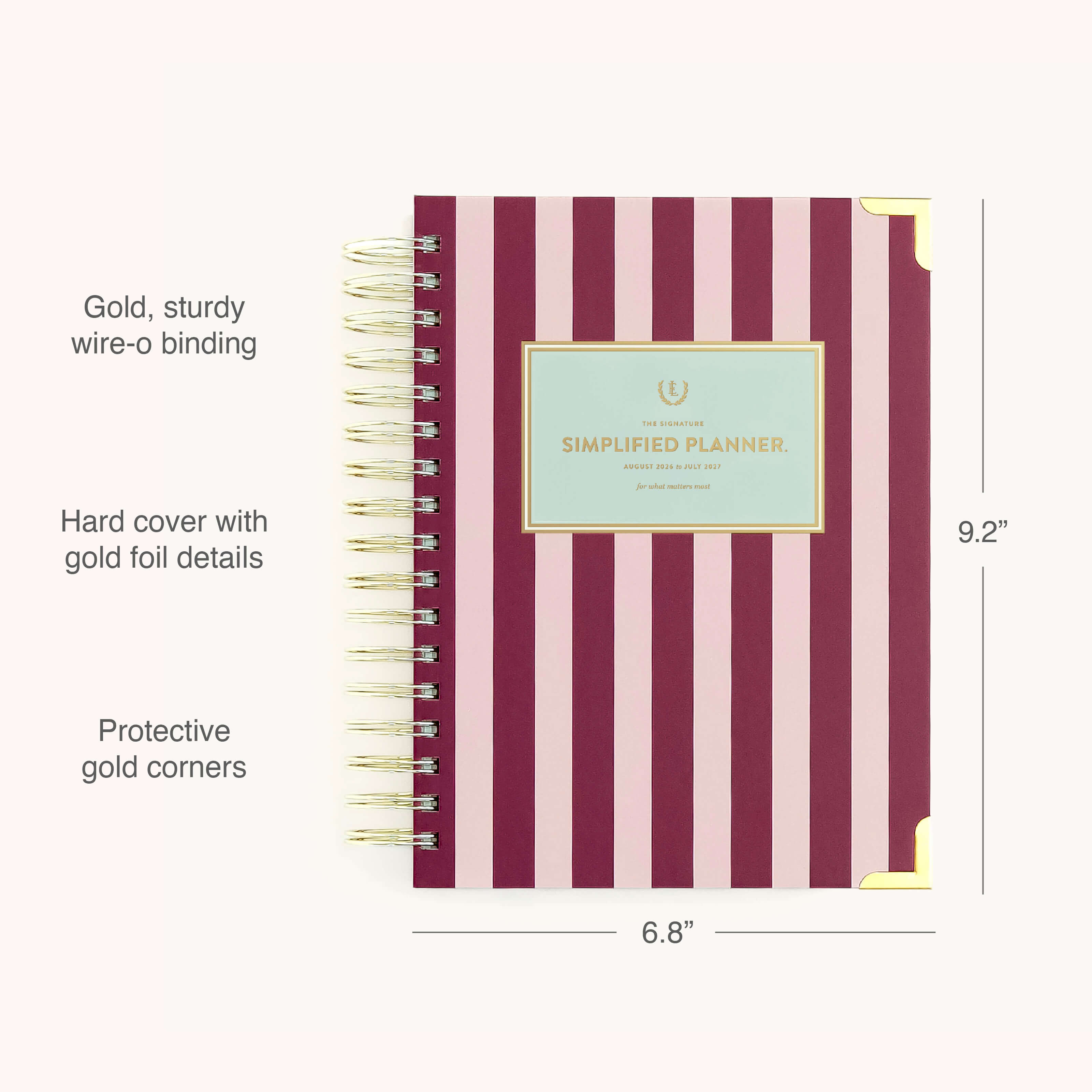 The Simplified 2026-2027 Spiral Daily Simplified Planner – Berry Stripe features a navy berry and pink stripe hardcover with gold wire-o binding, gold foil floral accents, and protective corners. Size: 9.2 x 6.8.
