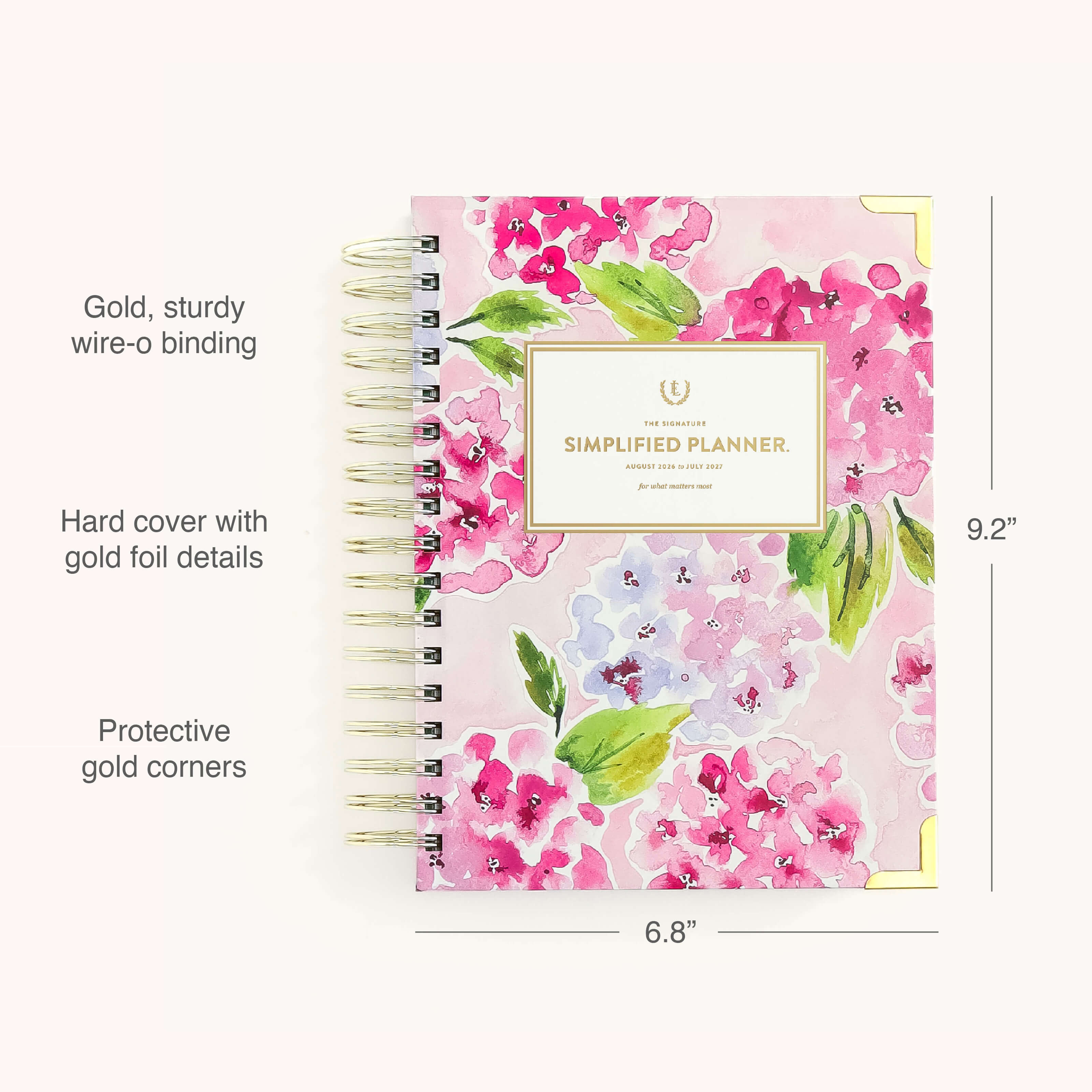 The Simplified 2026-2027 Spiral Daily Simplified Planner – Blush Hydrangea features a pink floral hardcover with gold wire-o binding, gold foil floral accents, and protective corners. Size: 9.2 x 6.8.