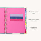 An open Simplified 2026 Spiral Weekly Simplified Planner - Rainbow Row shows a bright raspberry interior, colorful tab dividers, double-sided pink pocket with a transparent sticker sheet, and its weekly features highlighted on the right.
