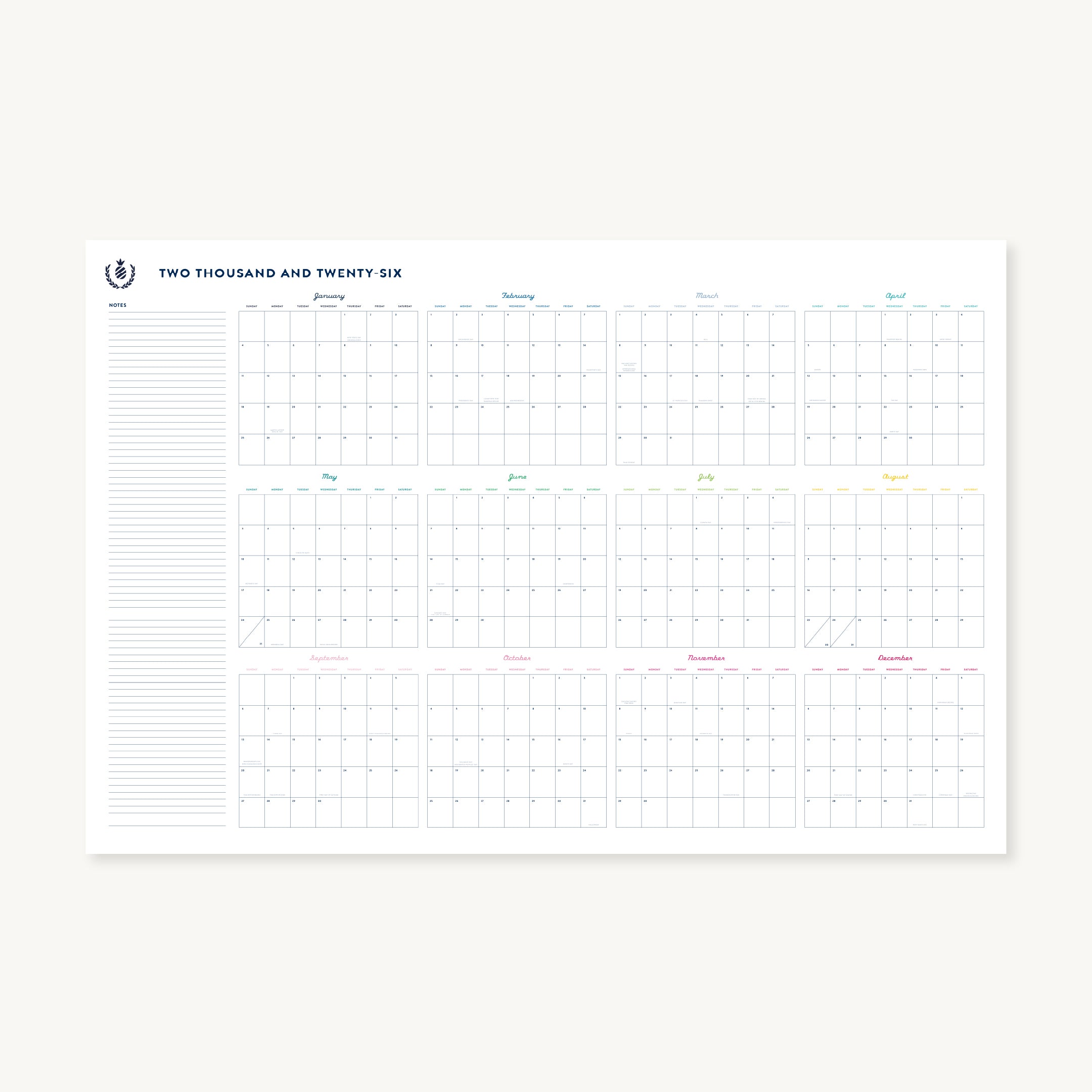The Simplified 2026 Wall Calendar - Printable shows all twelve months in a grid, each with its own section, and features a lined notes area on the left plus a simple crest logo in the top left corner.