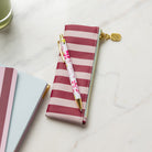Berry Stripe Petite Pen Case styled on desk with pen on top