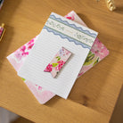Blush Hydrangea Page Marker on stack of notebooks