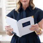 Woman holding Carolina Trellis bookbound weekly planner