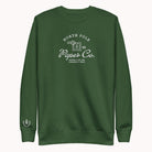 The Simplified® by Emily Ley Embroidered Crewneck - North Pole Paper Co is a hunter green holiday sweatshirt with white text, a mailbox design, "Making a list and checking it twice," and a small laurel wreath on the sleeve cuff.