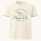 Stay cozy this holiday season in the Simplified Oversized T-Shirt - North Pole Paper Co, a cream-colored tee with green text and a festive postage stamp tree graphic, plus “Making a list and checking it twice” since ESTD 2008.