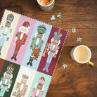 Nutcrackers 500-Piece Jigsaw Puzzle completed on a wood table with a few loose pieces and a cup of coffee